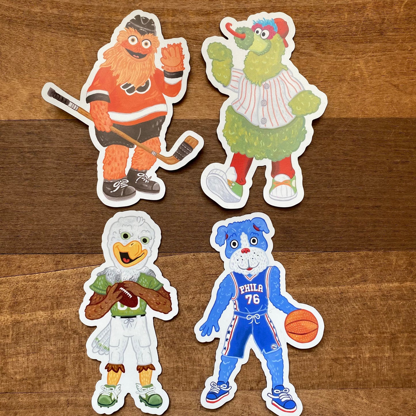 Four Philly Mascot Magnets, including Gritty, on a wooden surface by Jamie Bendas.