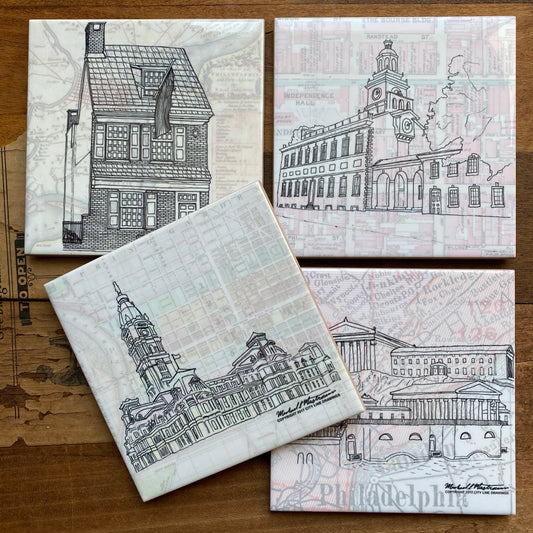 Four Philly Landmark Coasters featuring black and white line drawings of Philadelphia landmarks on a wooden background by City Line Drawings.
