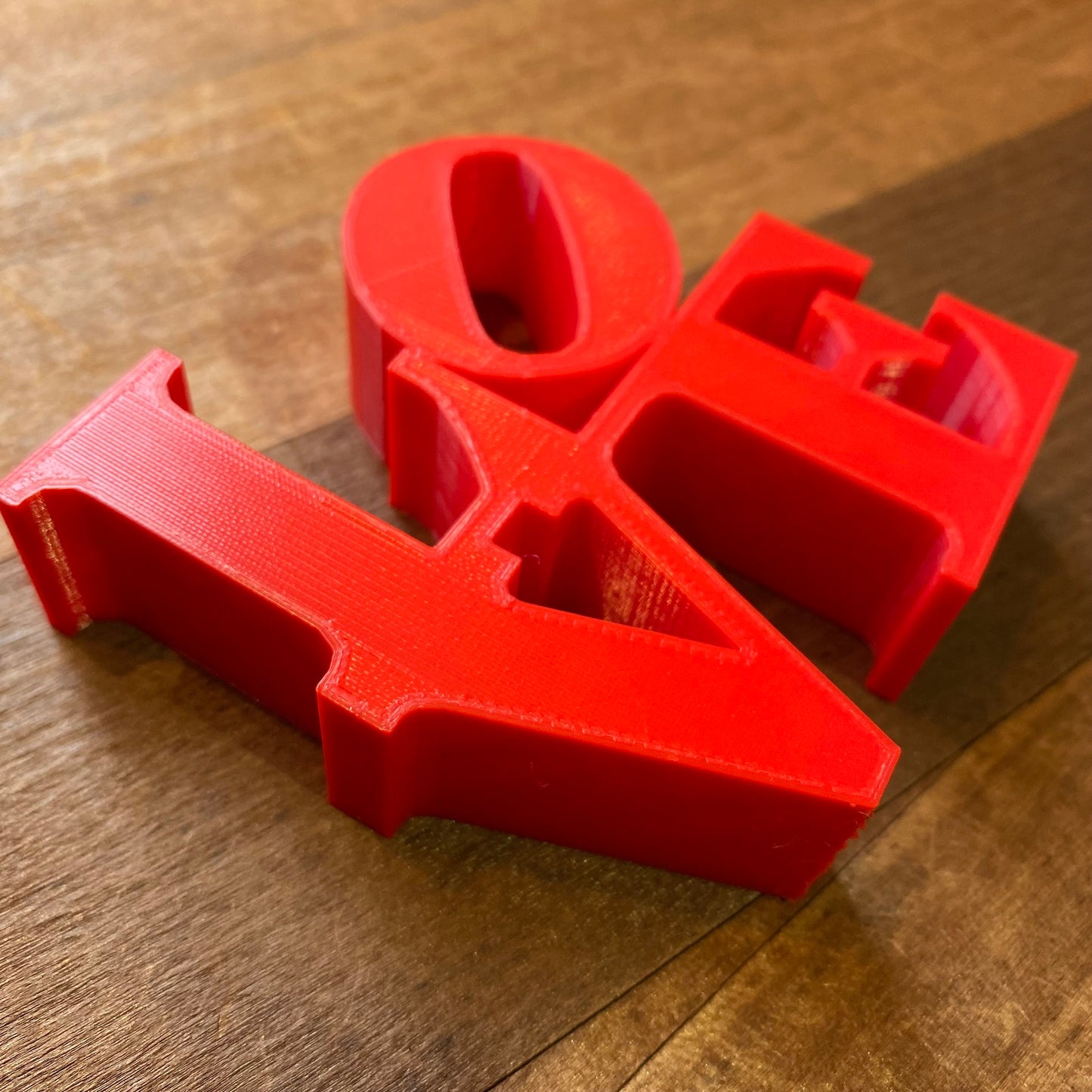 Red Rosewood Home LOVE Statue letters spelling "ok" on a wooden surface are a trendy addition to home decor.