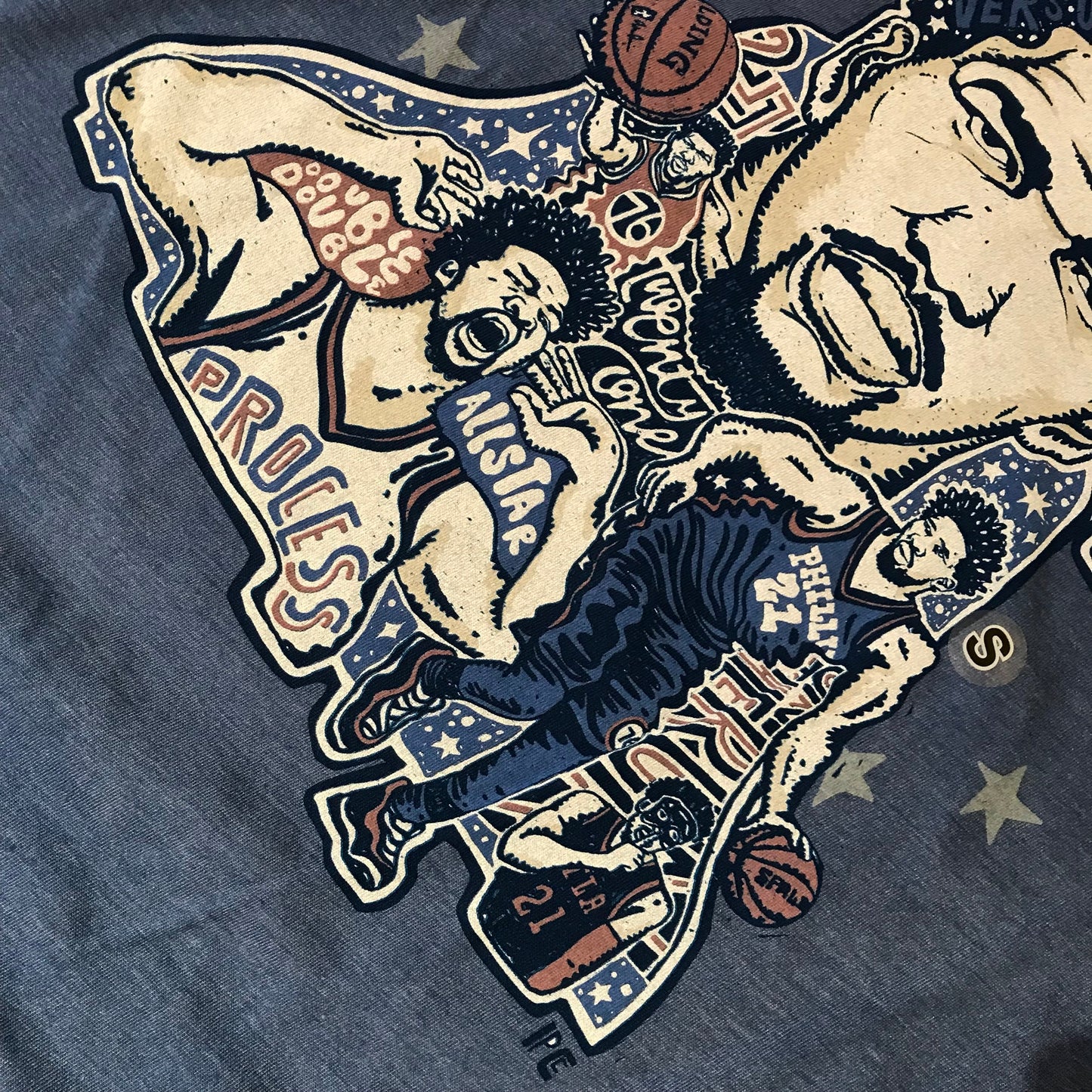 Illustration of Sixers Joel Embiid T-Shirt and various basketball-themed designs on a gray fabric by Paul Carpenter.