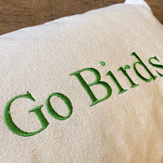 A close-up of a beige 100% unbleached cotton drill fabric with the phrase