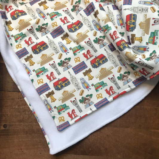 Fabric made of organic cotton, featuring a colorful pattern of cartoon furniture and household items, perfect as a Philly Baby Blanket design by Ana Thorne.