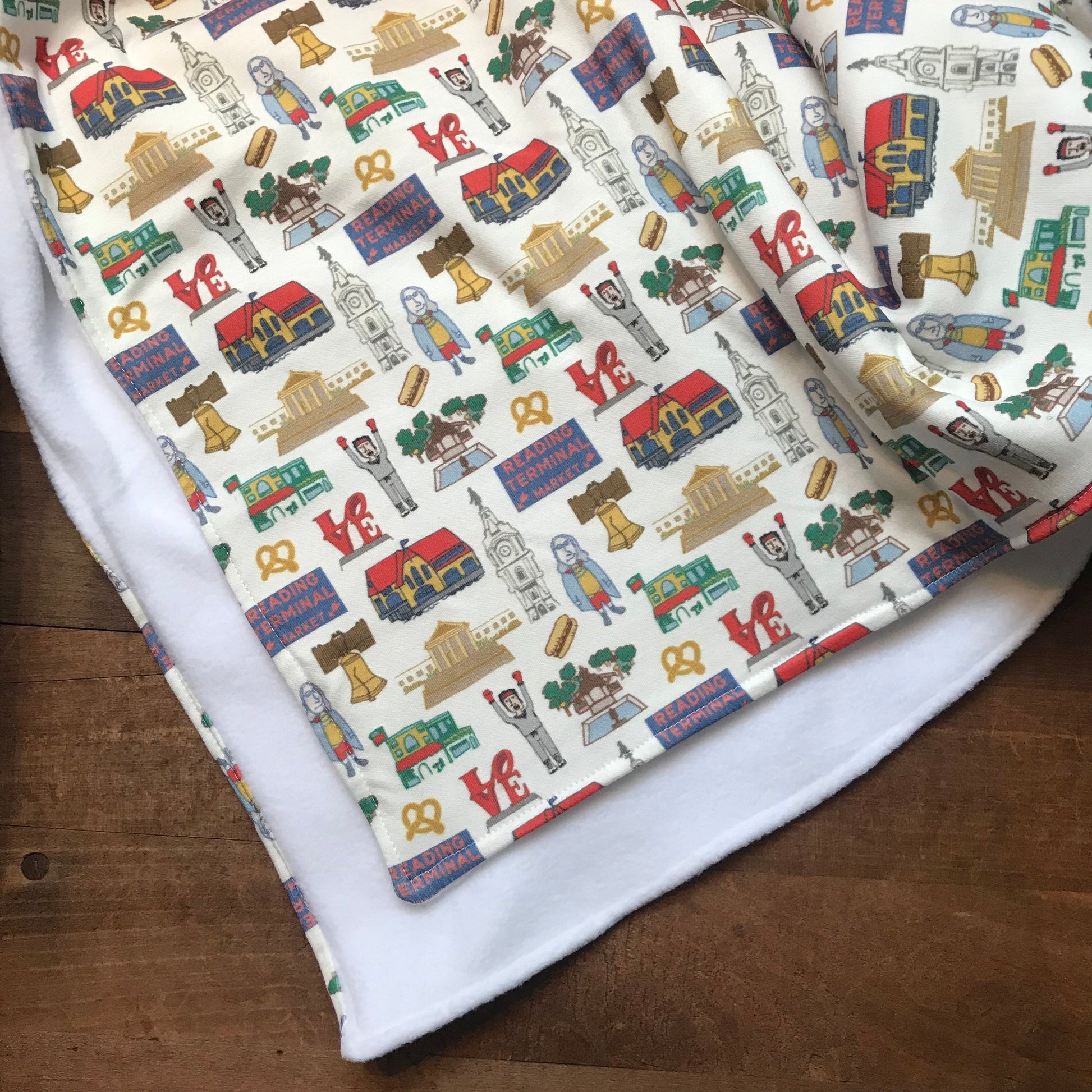 Fabric made of organic cotton, featuring a colorful pattern of cartoon furniture and household items, perfect as a Philly Baby Blanket design by Ana Thorne.