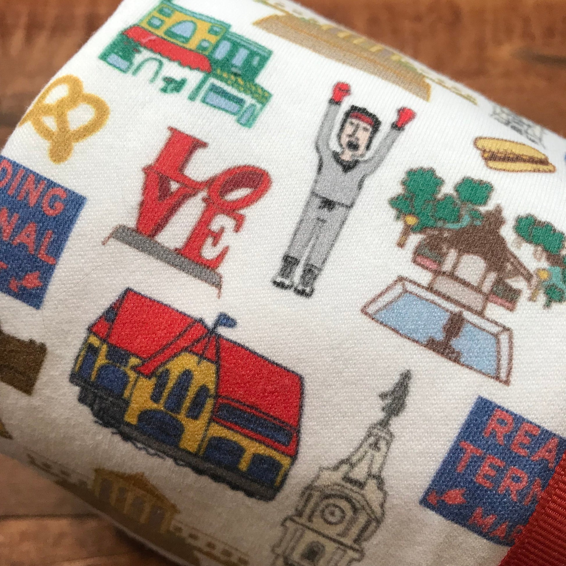 Patterned organic cotton fabric with a variety of colorful designs, including the word "love," an astronaut, vehicles, and other assorted symbols, like the Ana Thorne Philly Baby Blanket.