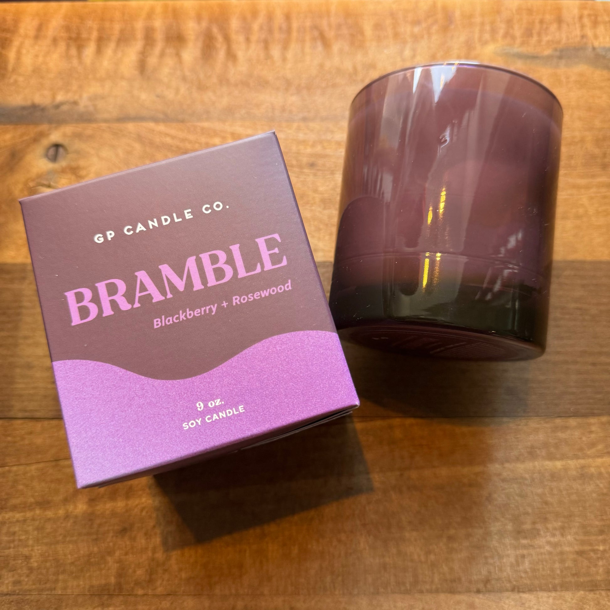 A hand-poured scented Soy Candles-Hue Collection named "bramble" with blackberry and rosewood fragrance, alongside its packaging box on a wooden surface by GP Candle Co.