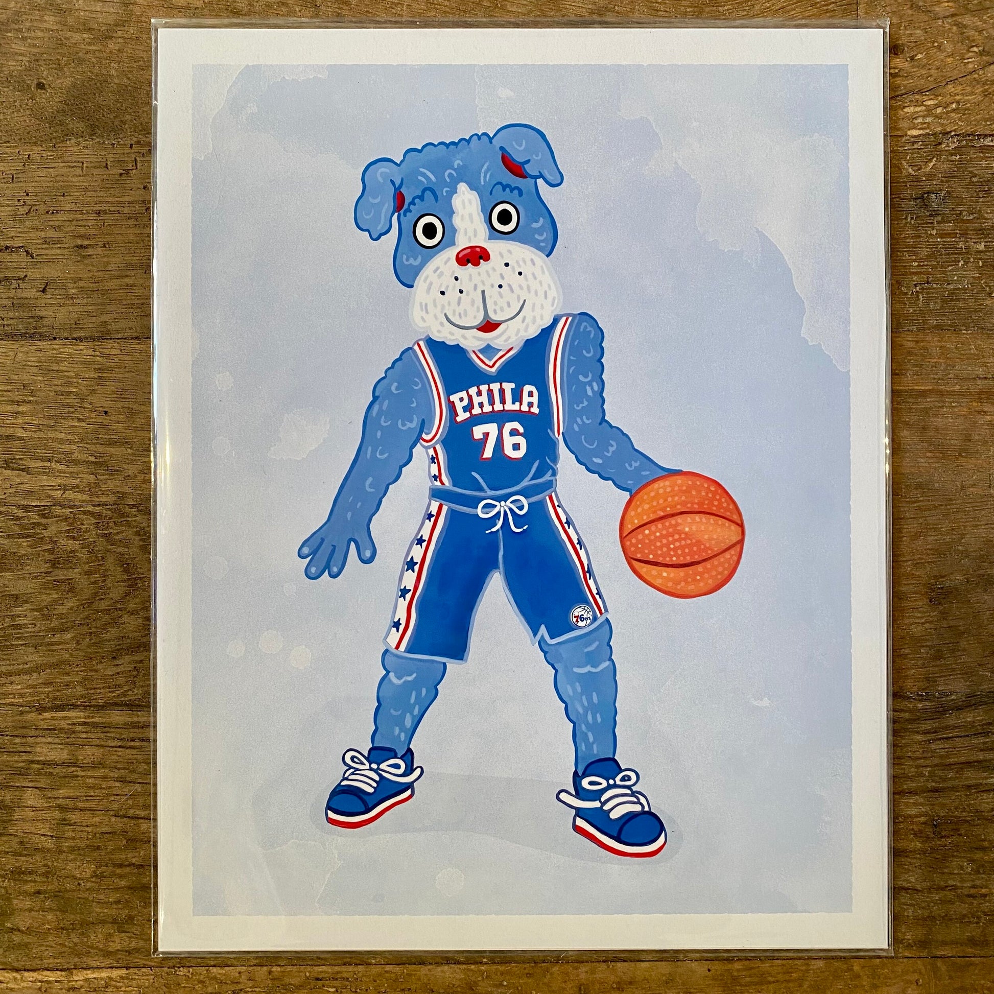 Illustration of a gritty cartoon dog character wearing a Philly Mascot Prints basketball jersey and dribbling a basketball by Jamie Bendas.