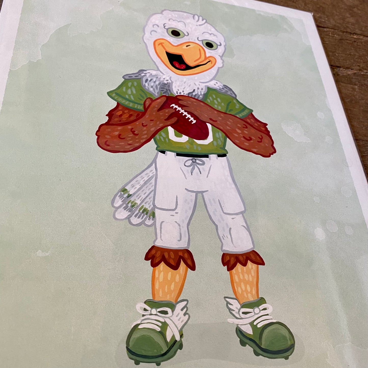 Illustration of an anthropomorphic chicken, reminiscent of the gritty style of Jamie Bendas, dressed in football attire holding a football - Philly Mascot Prints by Jamie Bendas.