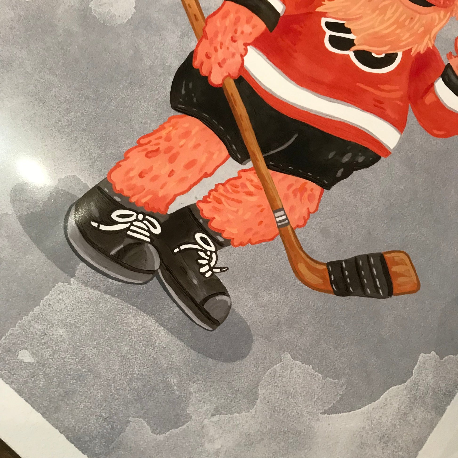Illustration of a person's lower body wearing ice skates and a hockey uniform while holding a hockey stick, created by Jamie Bendas for Philly Mascot Prints.