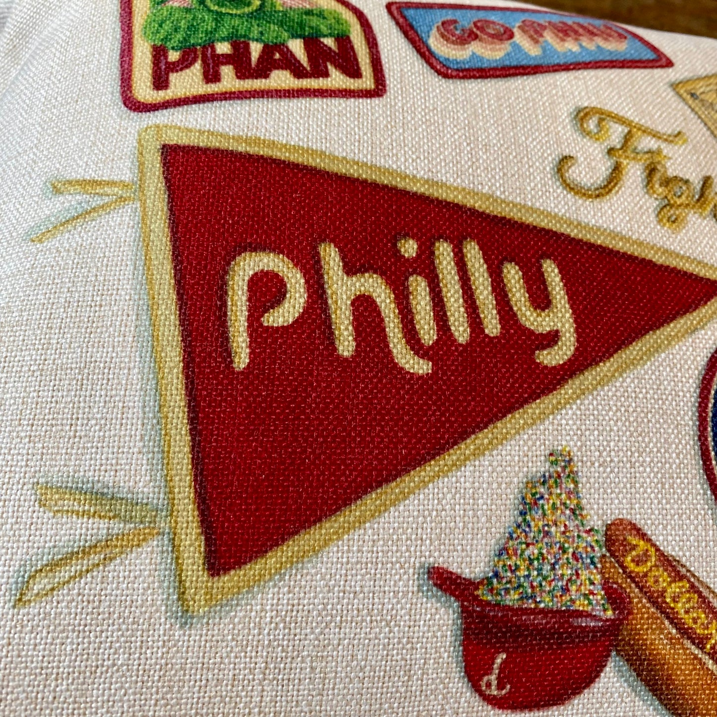 Close-up of an embroidered textile featuring a red pennant with the word "philly" and other colorful designs, including Meadowbrook Lane Philly Illustrated Pillows.