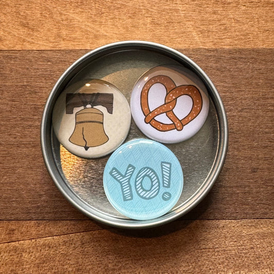 Three round badges with different designs, including a exit343design Philly Magnet Set, inside a metal tin.