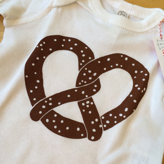 White cotton Pretzel Baby Onesie with a brown Philly pretzel design by exit343design.