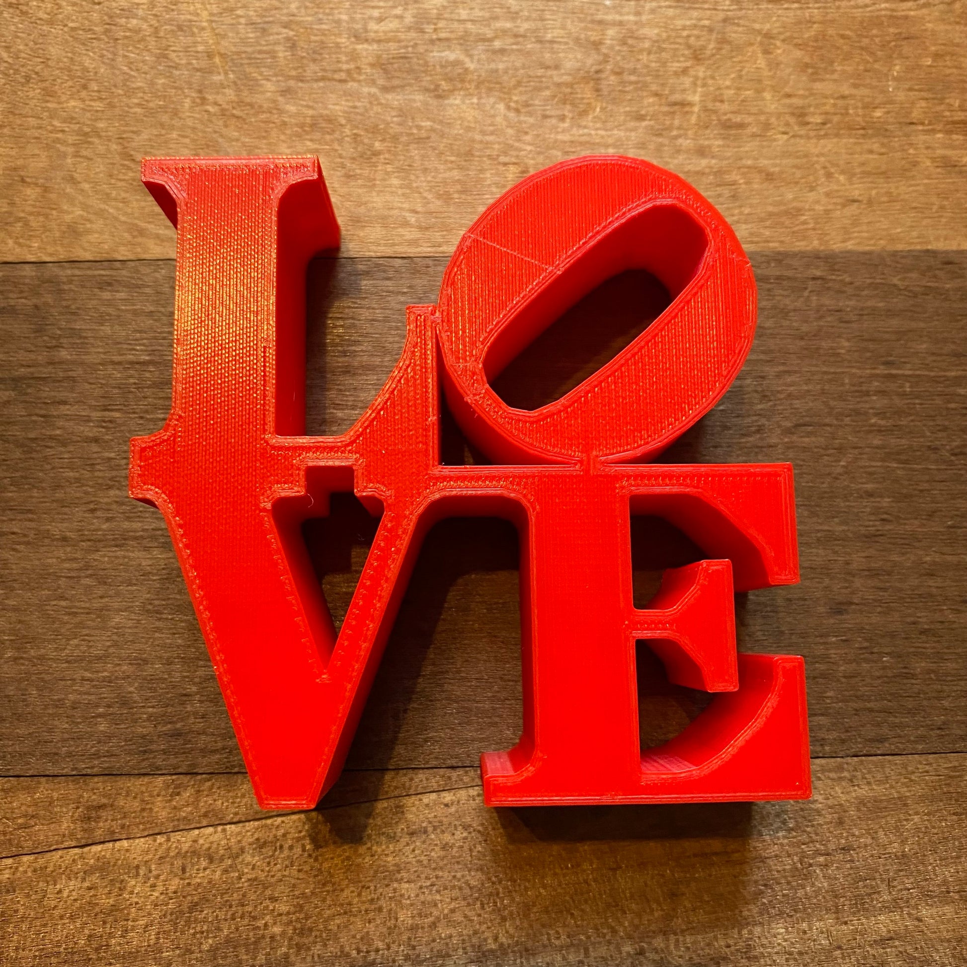 Red Rosewood Home LOVE Statue on a wooden surface, perfect for home decor.