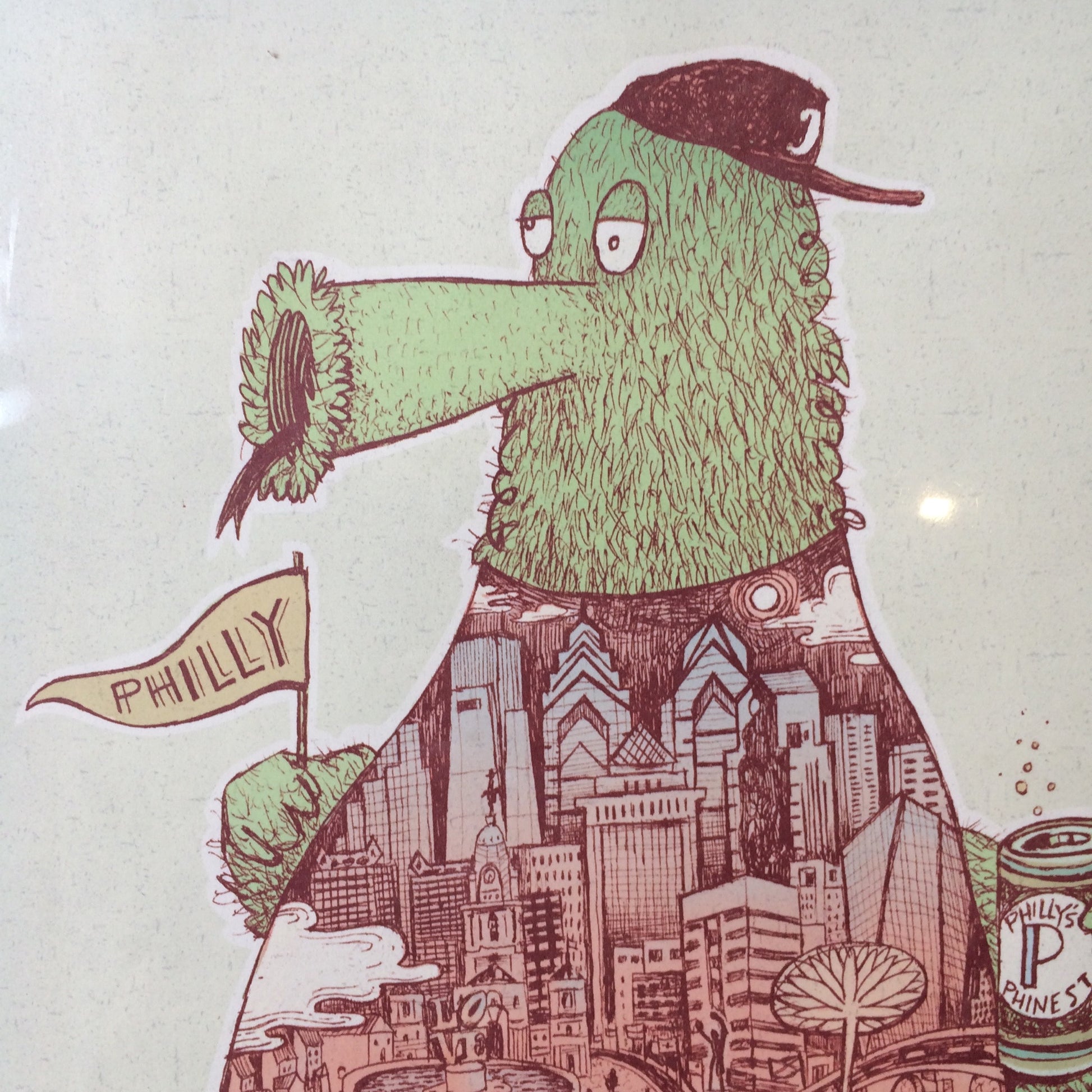 Illustration of a green, bird-like creature resembling the Phillies Phanatic, wearing a cap, with a small "philly" flag, set against a backdrop of Philadelphia's skyline is featured in the Phanatic Print by Paul Carpenter.