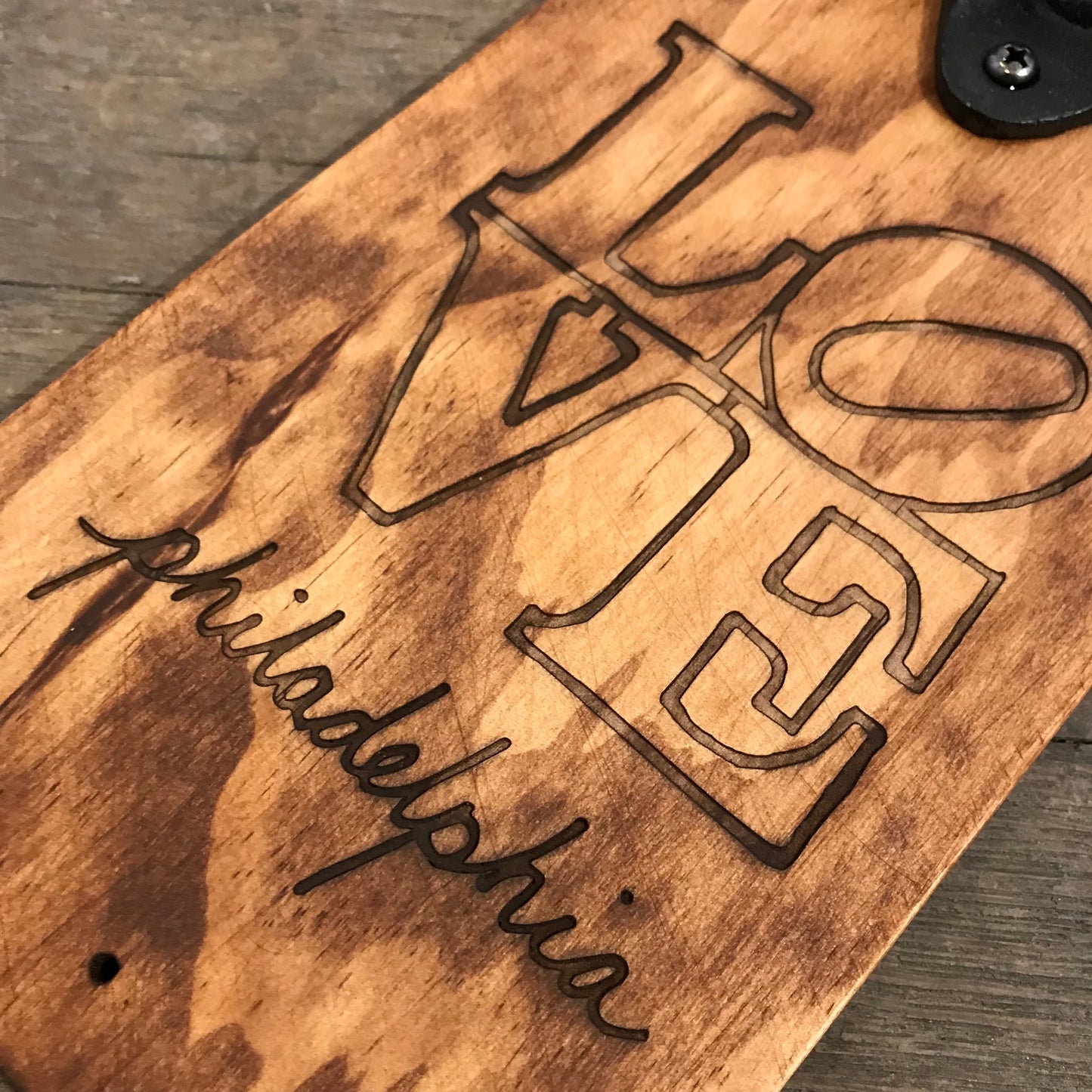 Wooden plaque with the word "love" and "Philadelphia" laser-etched, featuring iconic "love" sculpture design by Philly Phlights.