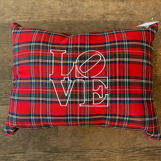 A red plaid Holiday Plaid Pillow from The Pillow Works, adorned with white letters spelling 