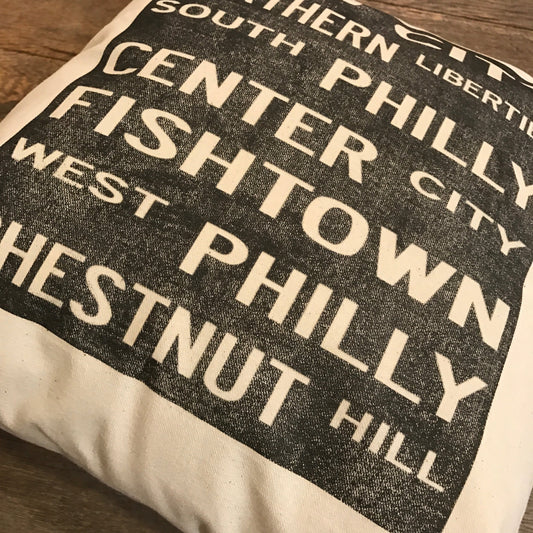 A Philadelphia Neighborhoods Pillow from The Pillow Works with names of Philly neighborhoods printed in various fonts on unbleached cotton drill fabric.