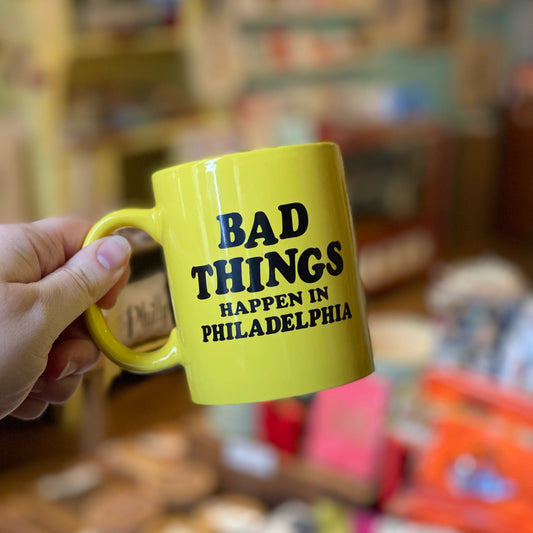 A person holding a pink bike Ralph Bad Things Mug with the text "bad things happen in Philadelphia" printed on it.