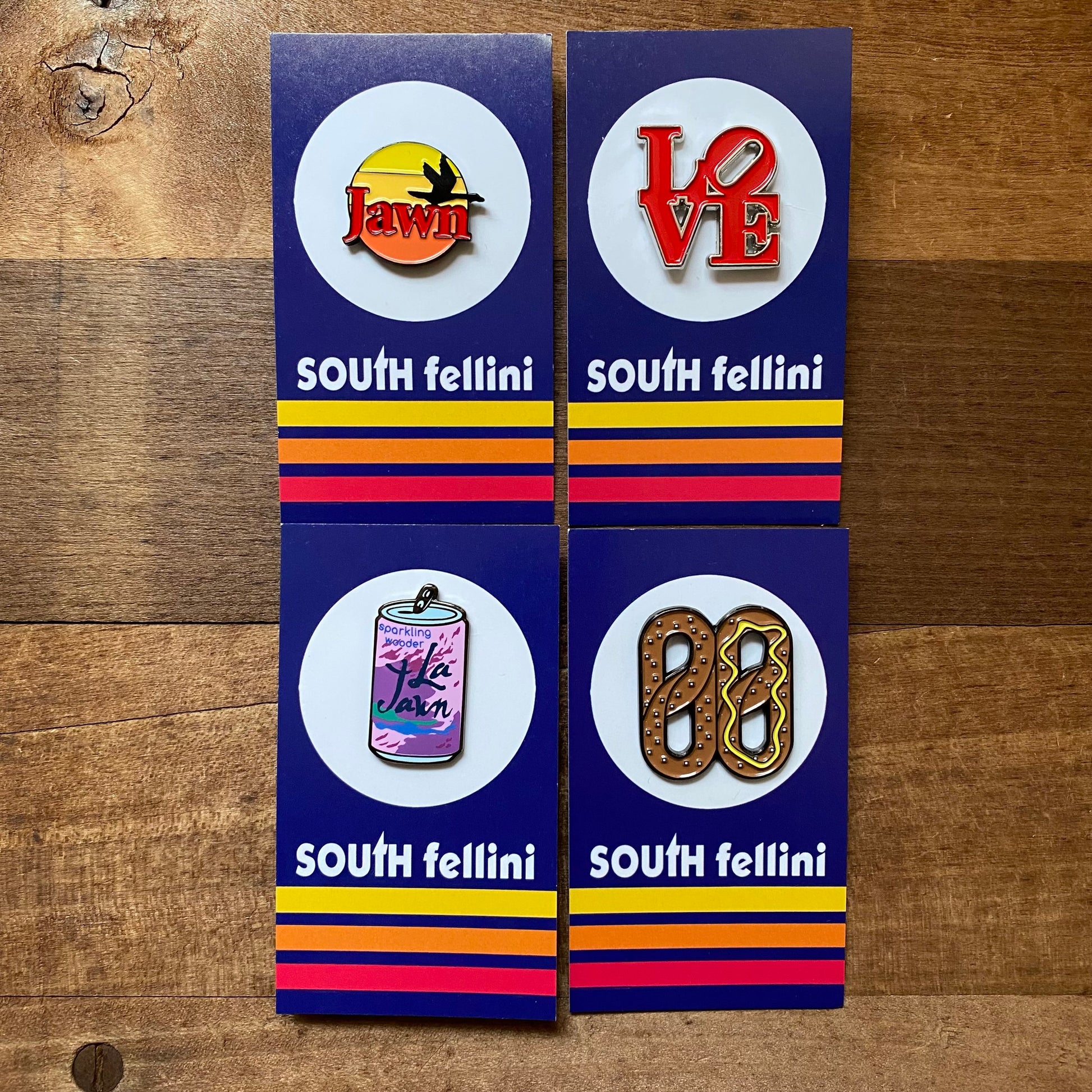 Four South Fellini Philly-Themed enamel pins featuring Philly icons on branded backing cards.