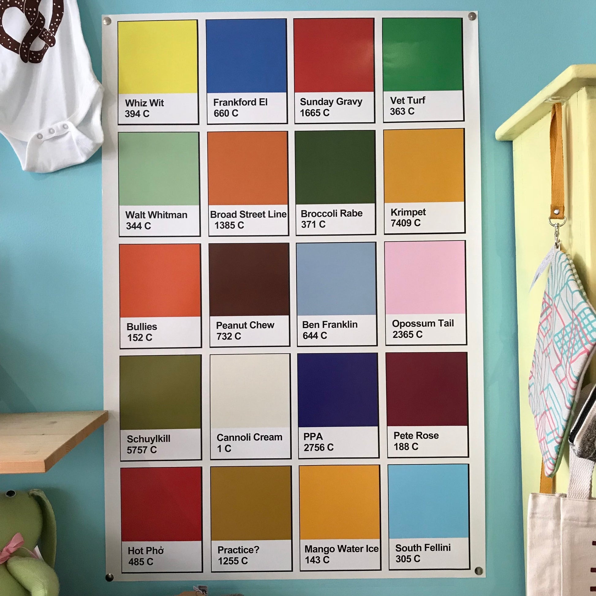 Color swatch chart on a wall with various shades named after Philadelphia gifts and cultural references, like the South Fellini Philly Palette Poster.