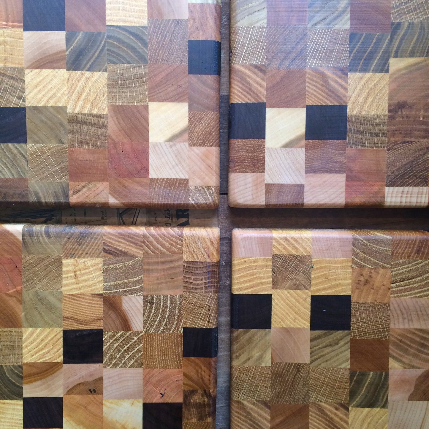 Four Steve Reid Checkerboard Wood Cutting Boards with checkerboard patterns of various light and dark wood tones.