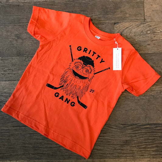 Orange Gritty Gang Toddler T-shirt with a cartoon character design of the Philadelphia Flyers mascot, Gritty, on a wooden floor by exit343design.